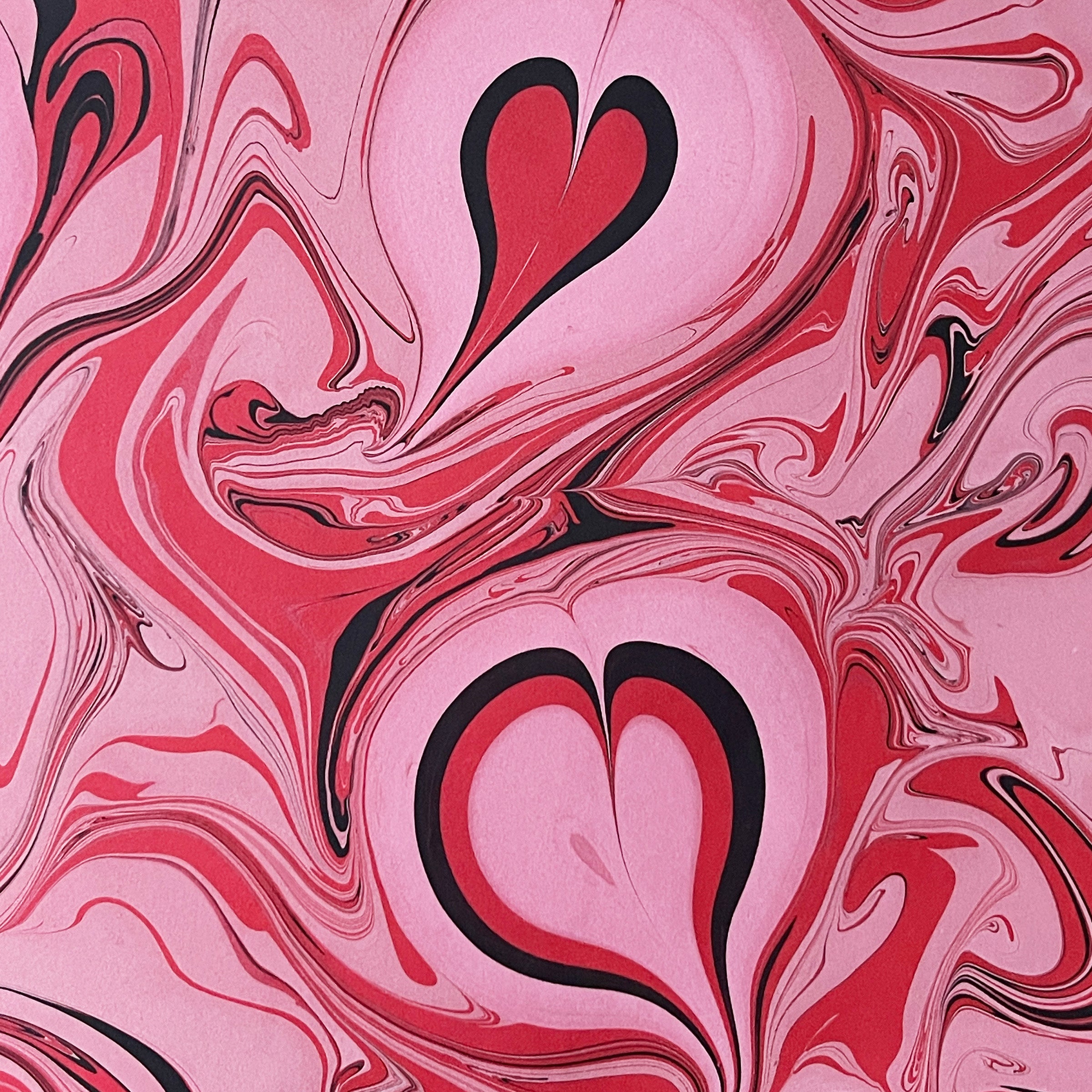 Marbled pattern with heart shapes in pink, red, and black.