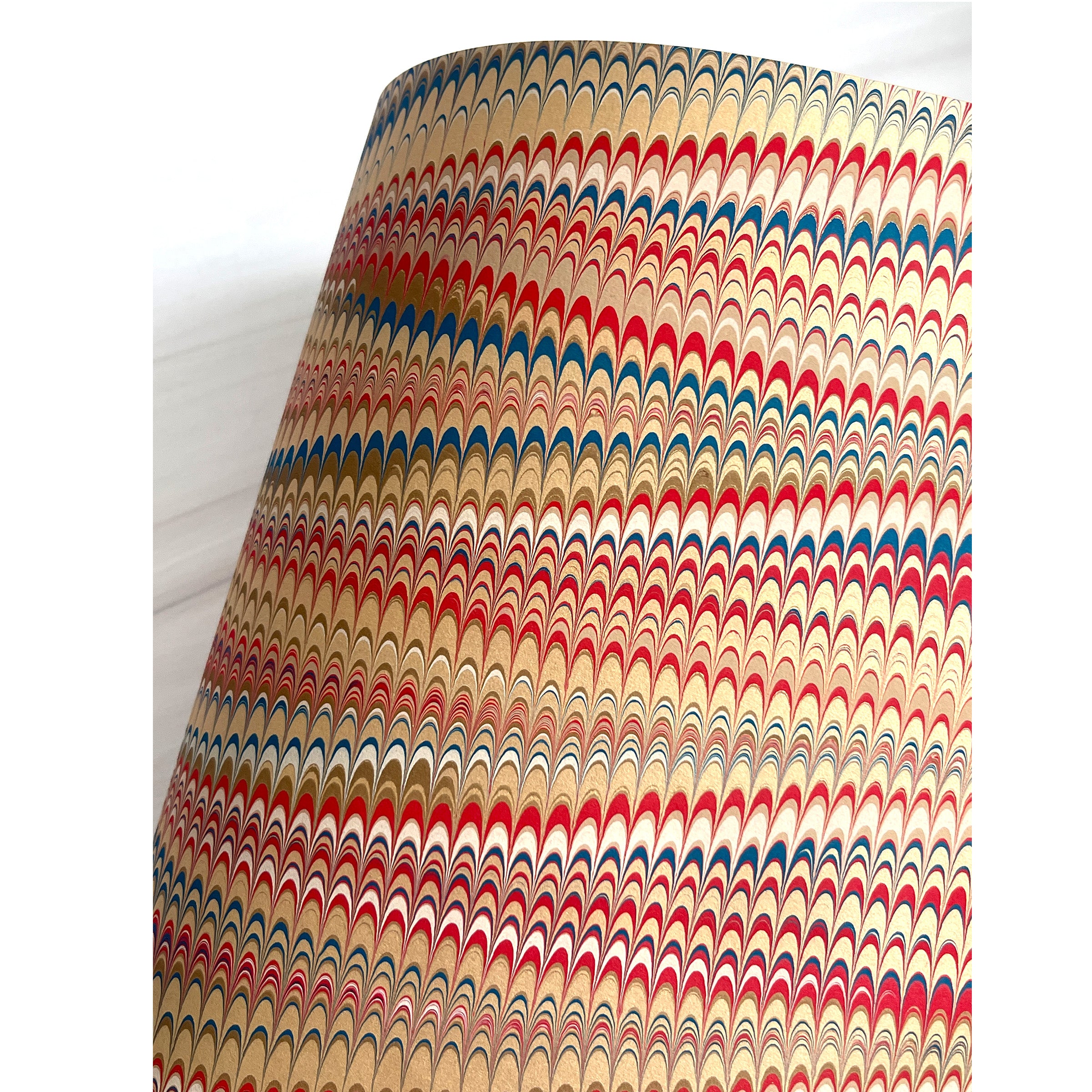 Marbled patterned paper with red, blue, and beige colors on a white background