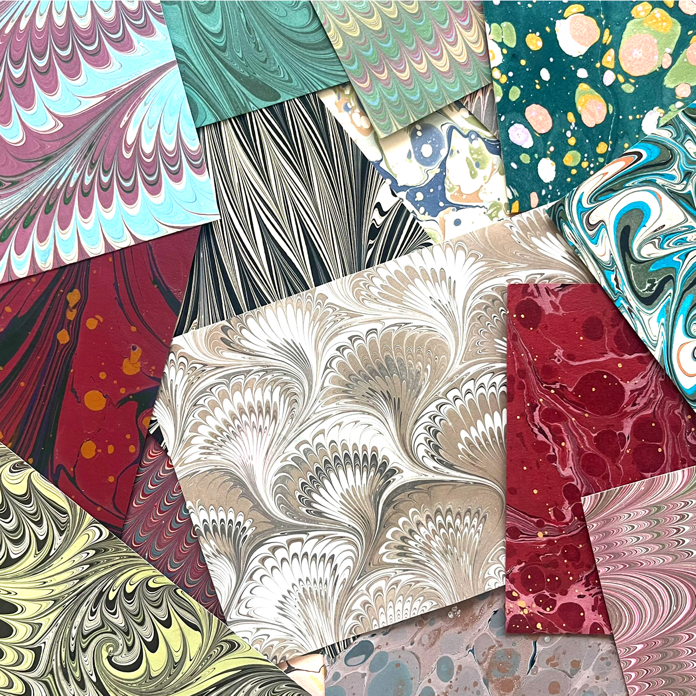 Collection of various marbled paper samples with different patterns and colors.