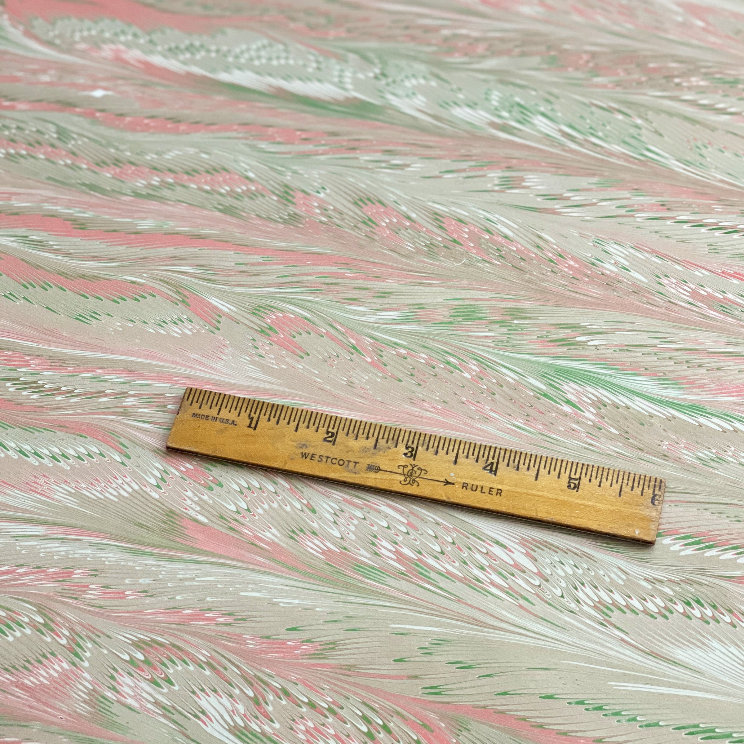 Marbled paper with a wooden ruler for scale.