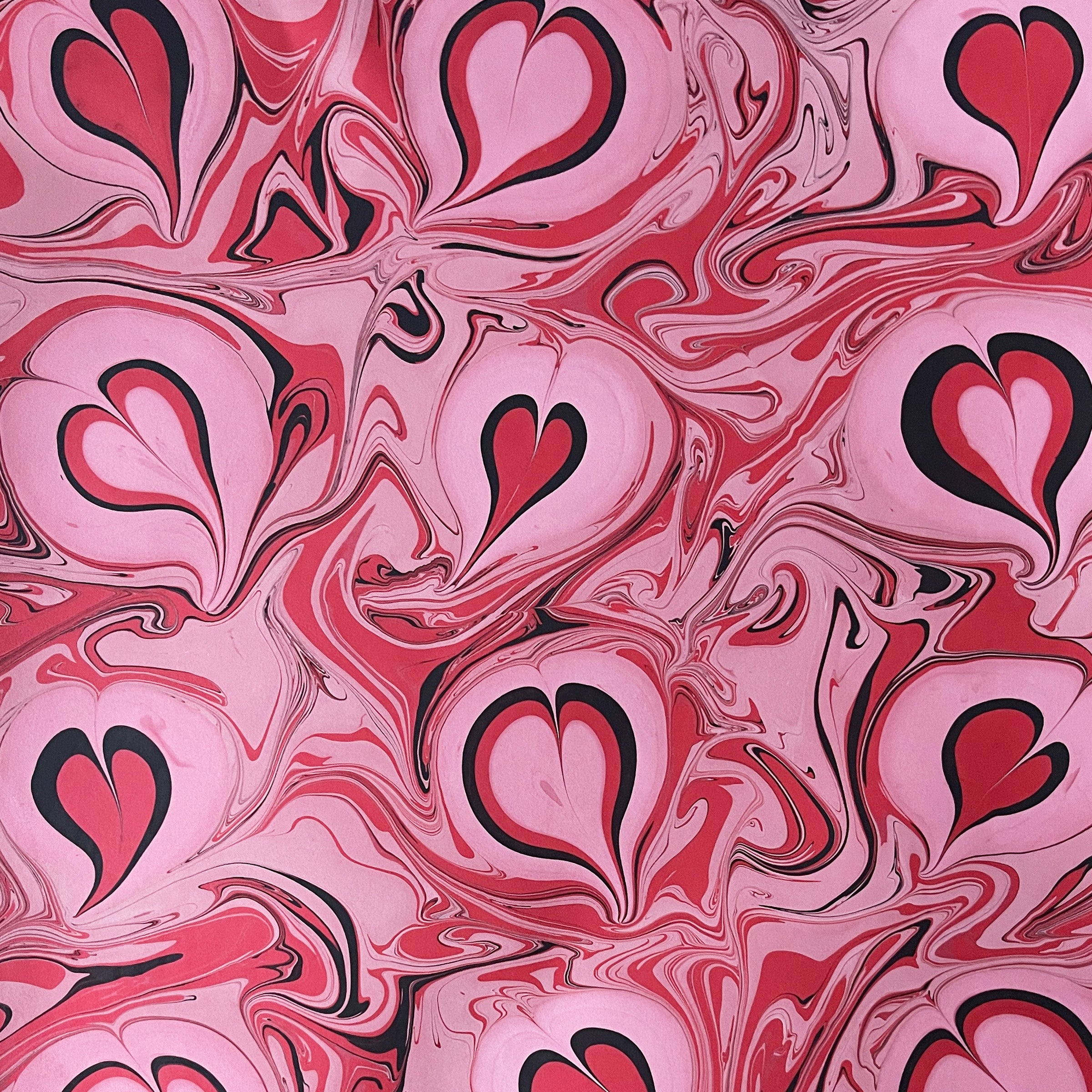 Pink and red heart pattern with black outlines on a pink background