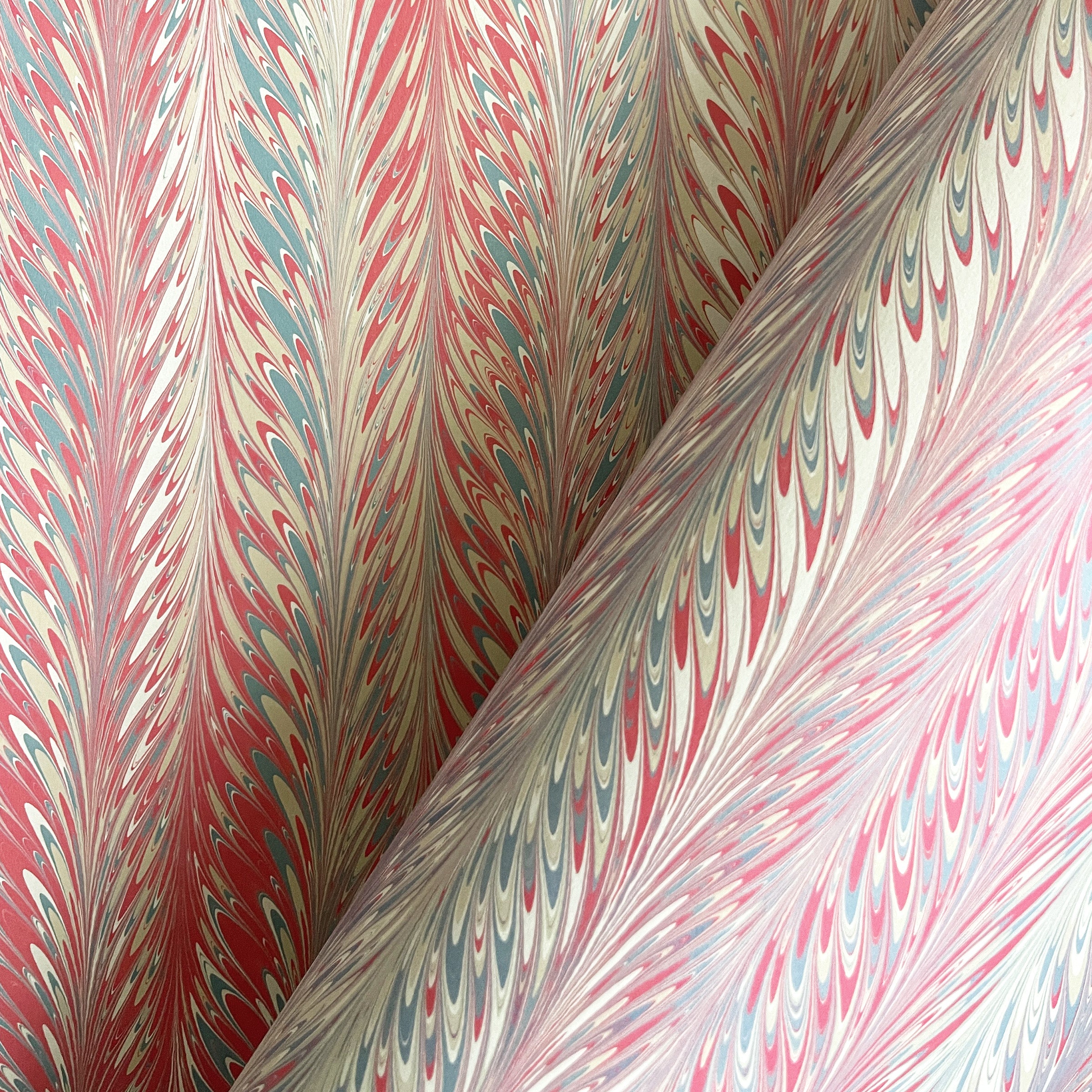 Marbled paper with a feathered design in salmon red, slate, and beige colors.