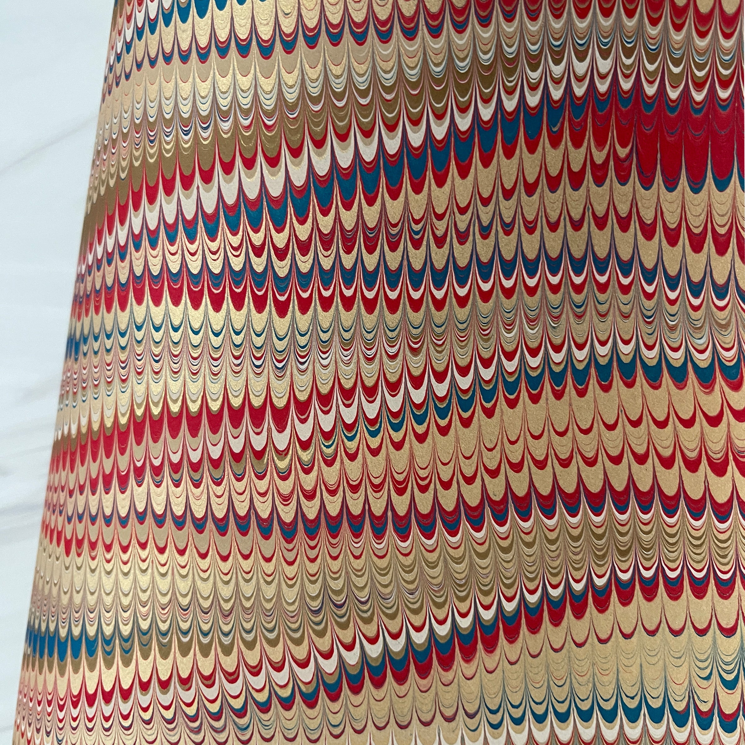 Close-up of marbled paper with red, white, and blue and gold nonpareil pattern 