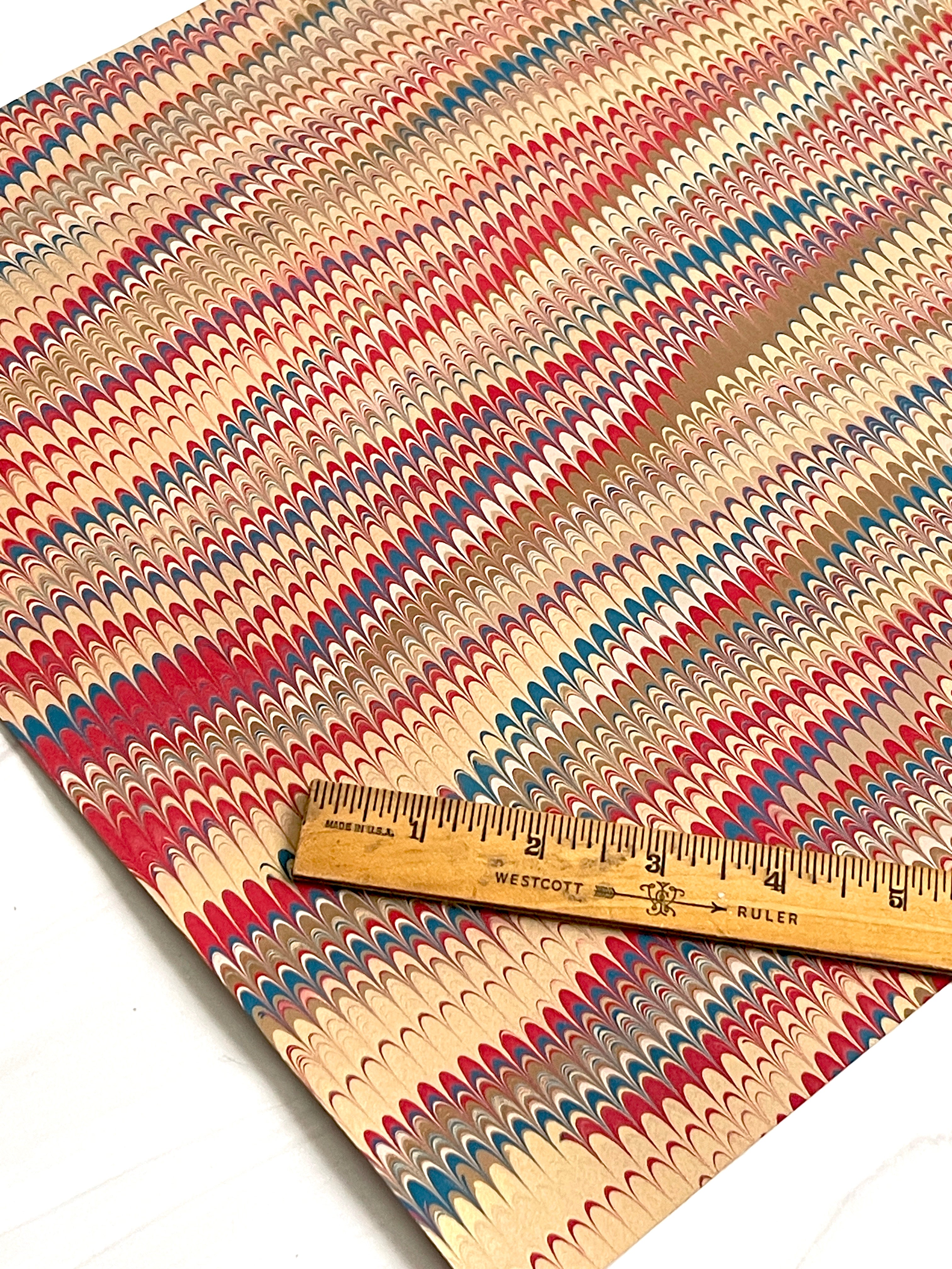 Colorful marbled paper with a wooden ruler for scale