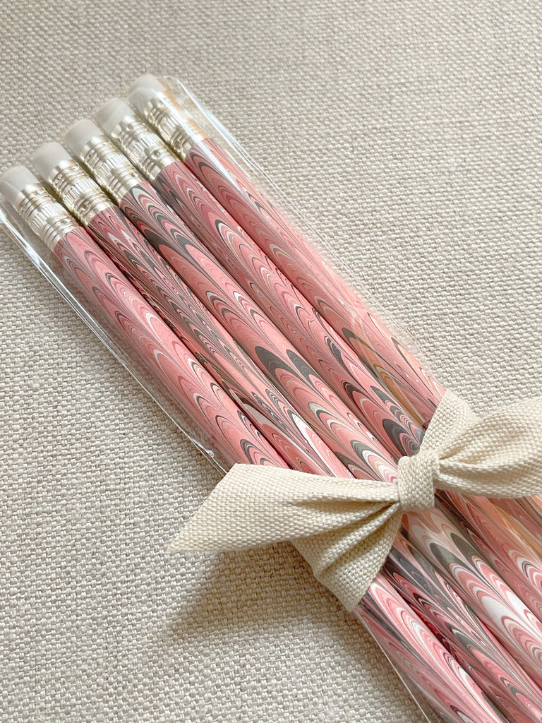 A set of five wooden pencils with a marbled paper design in pink and brown colors.