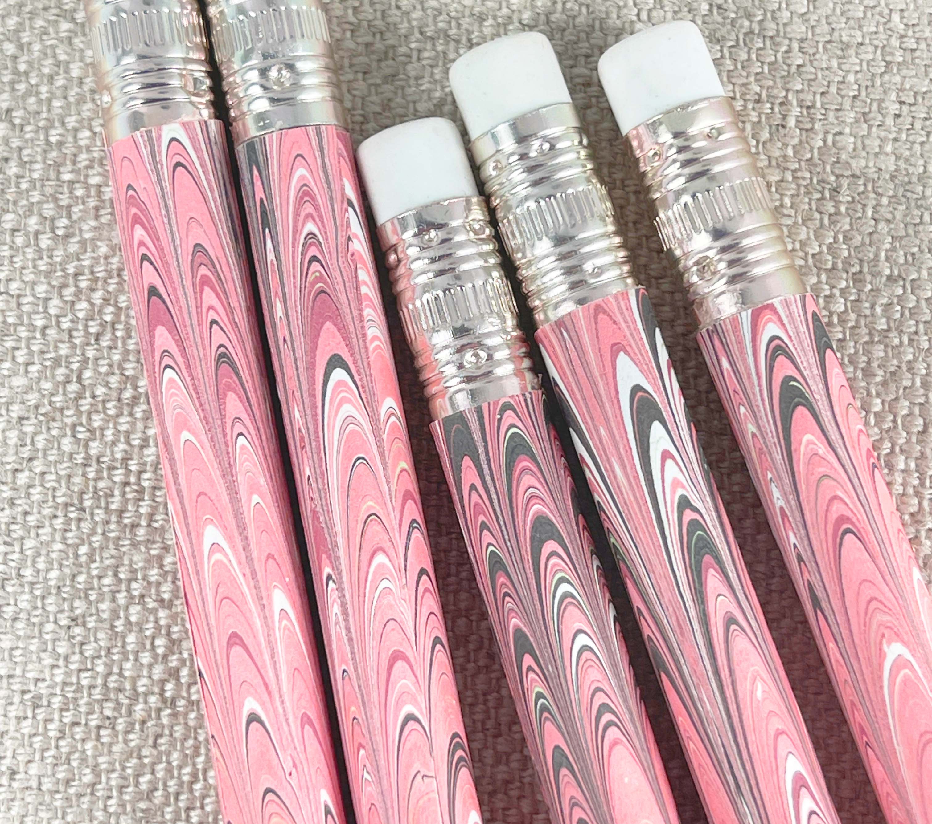 A set of five wooden pencils with a marbled paper design in pink and brown colors.
