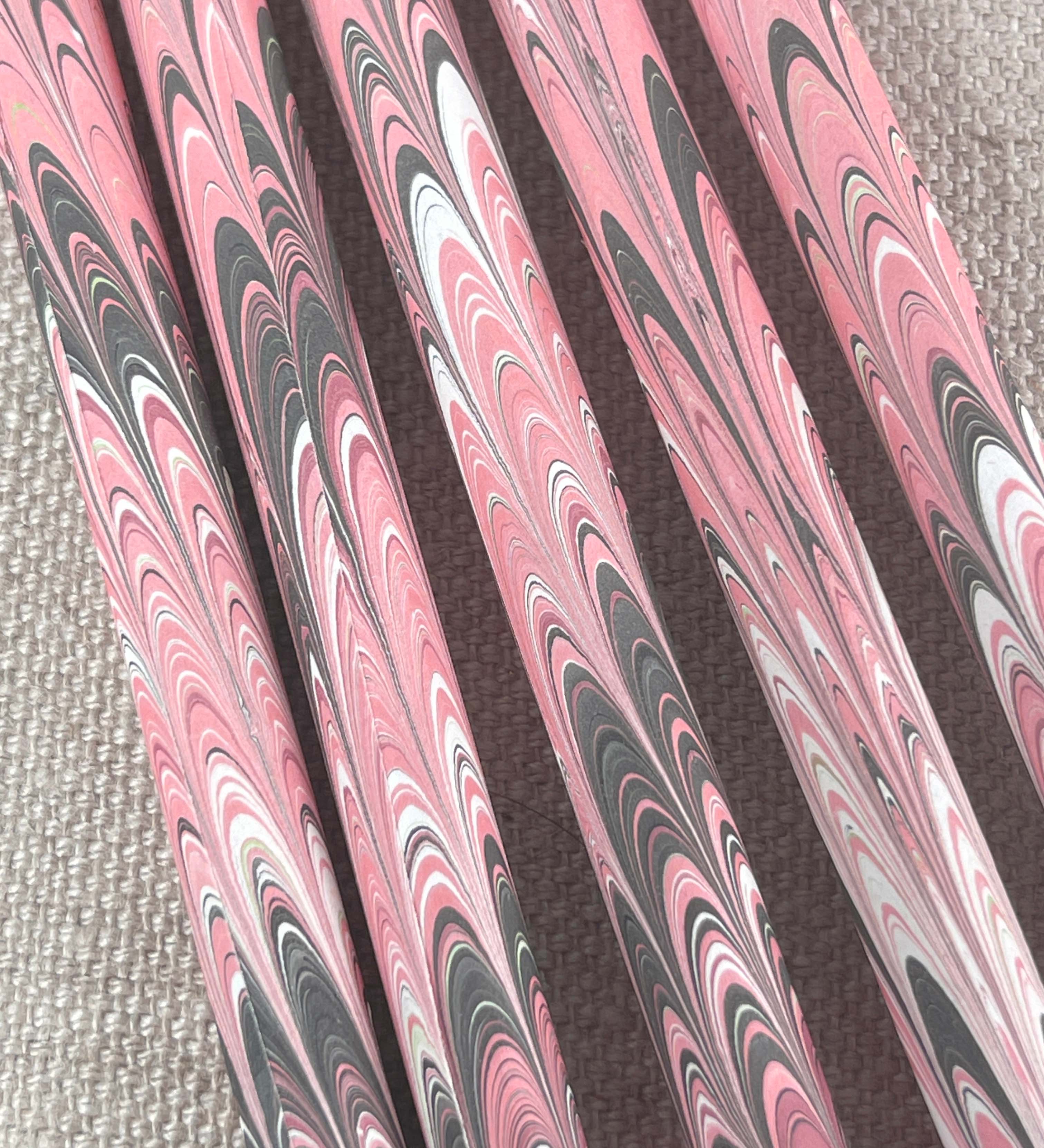 A set of five wooden pencils with a marbled paper design in pink and brown colors.